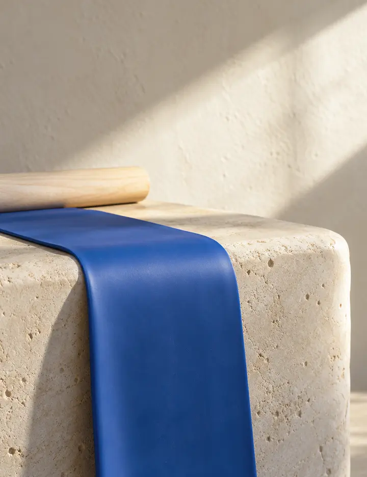 Generated illustration: a blue exercise band laid over a pale stone block in morning light.